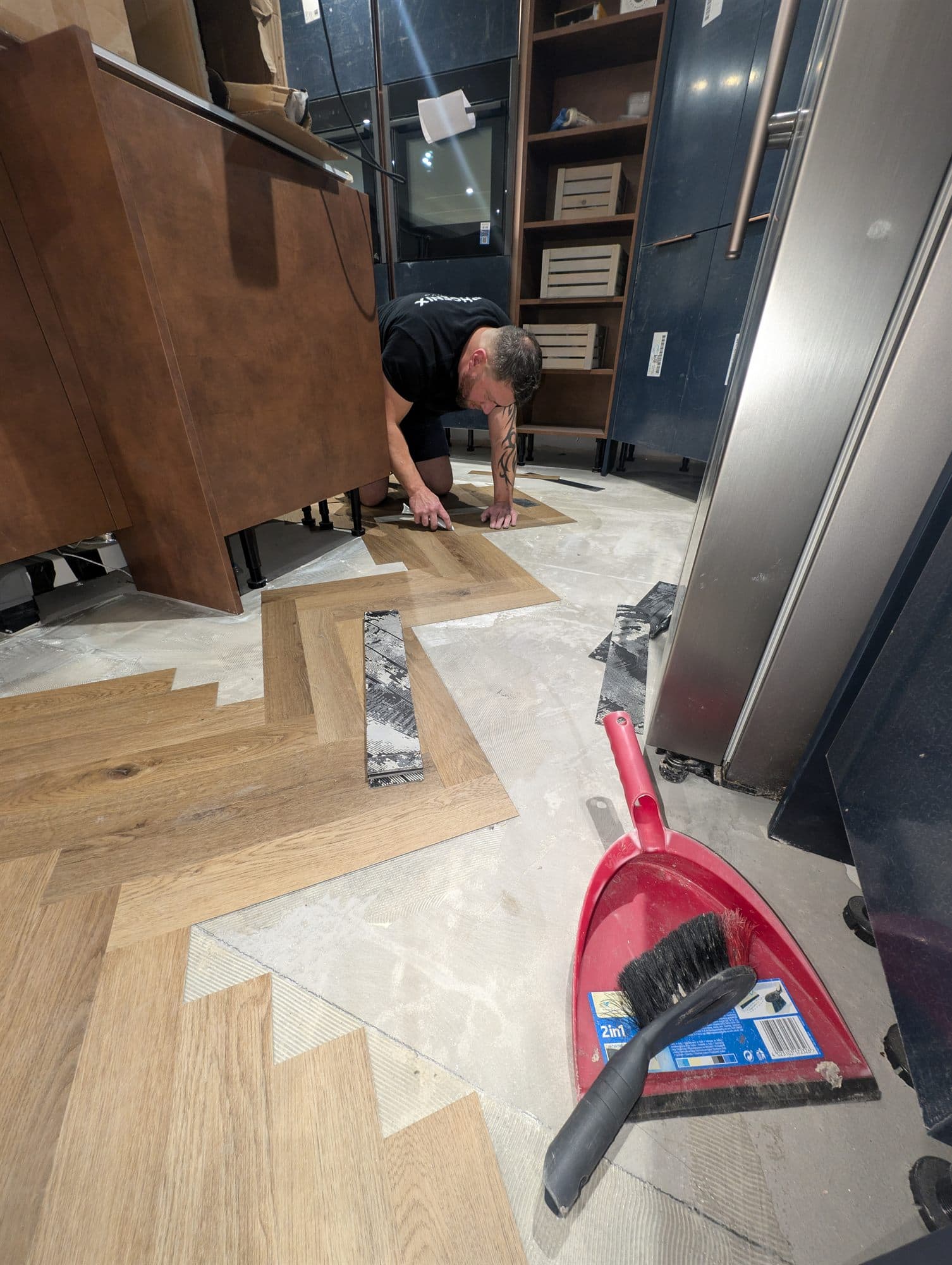 Herringbone flooring being laid by hand, with the pattern set out across the floor