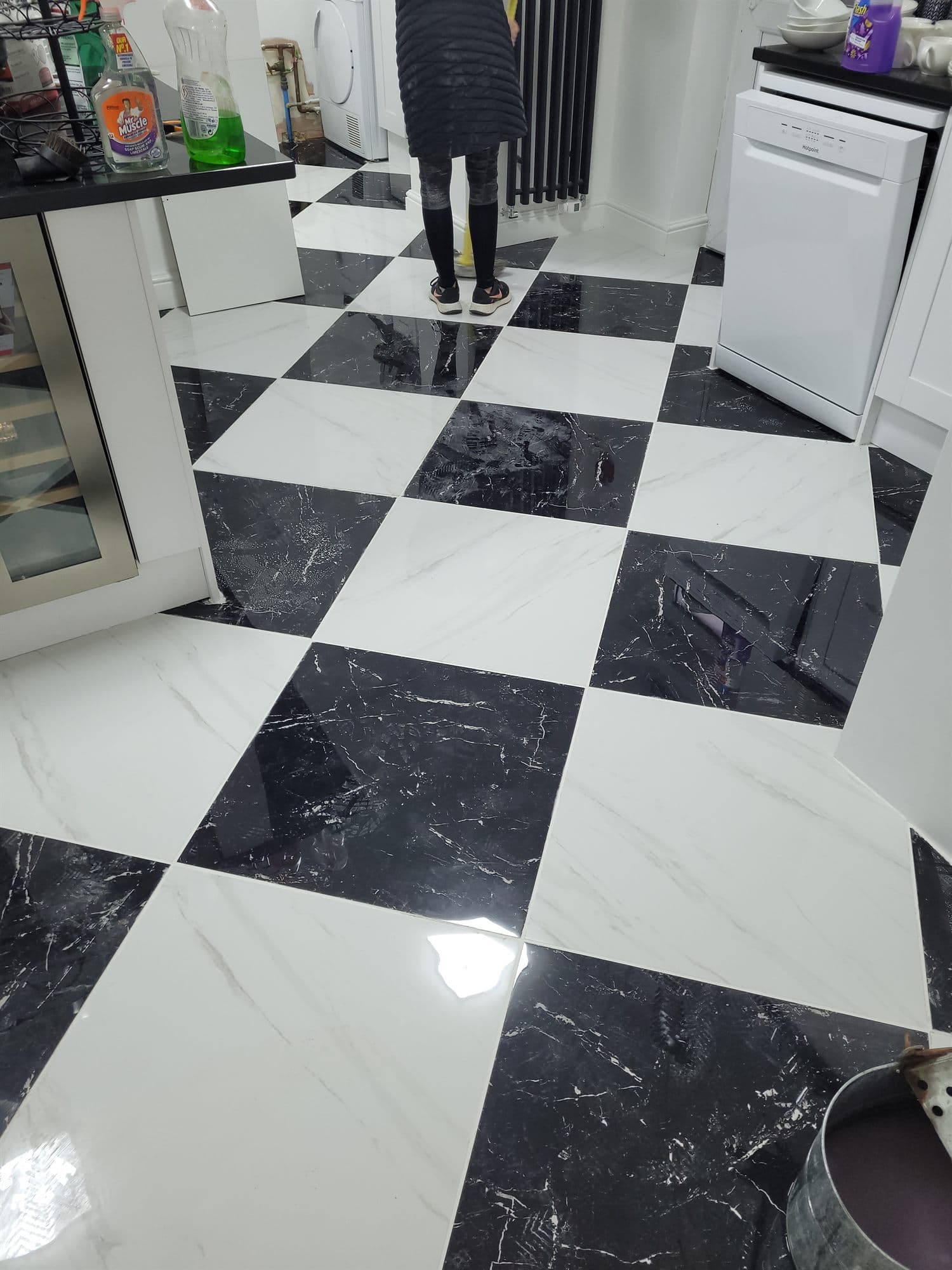 Large-format black and white marble-effect floor tiles laid in a chequerboard pattern