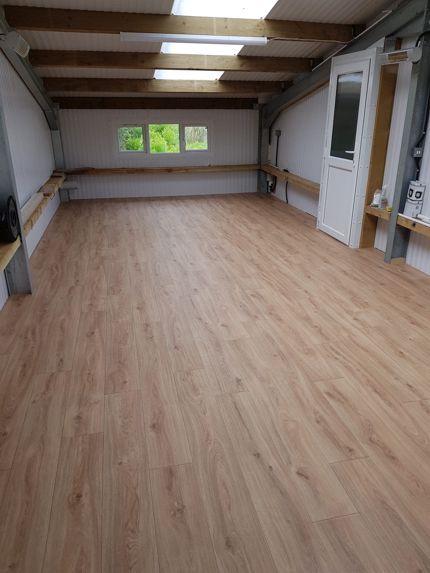 Long timber-framed room finished with wood-effect flooring
