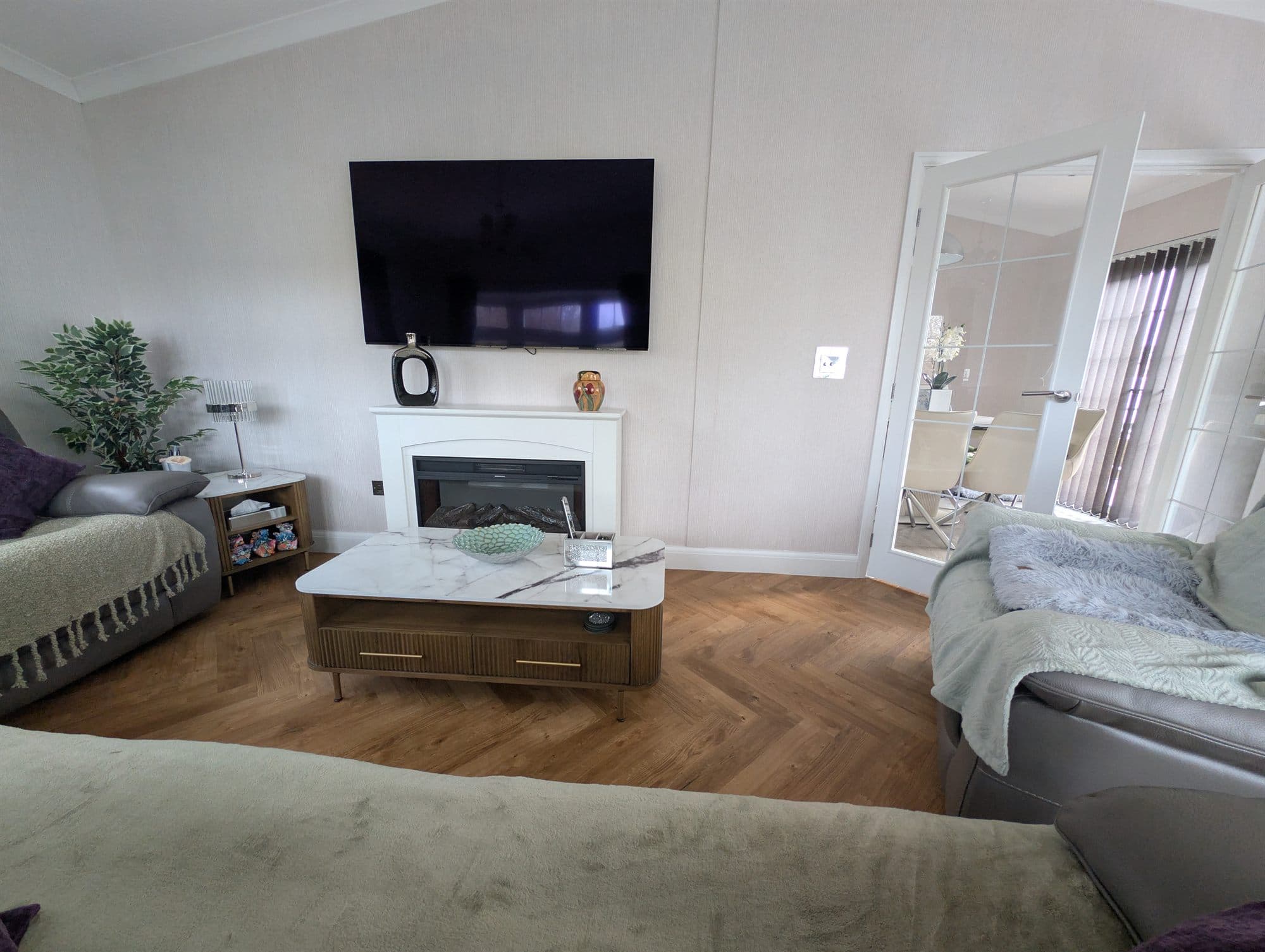 Living room with wood-effect herringbone flooring and a fireplace